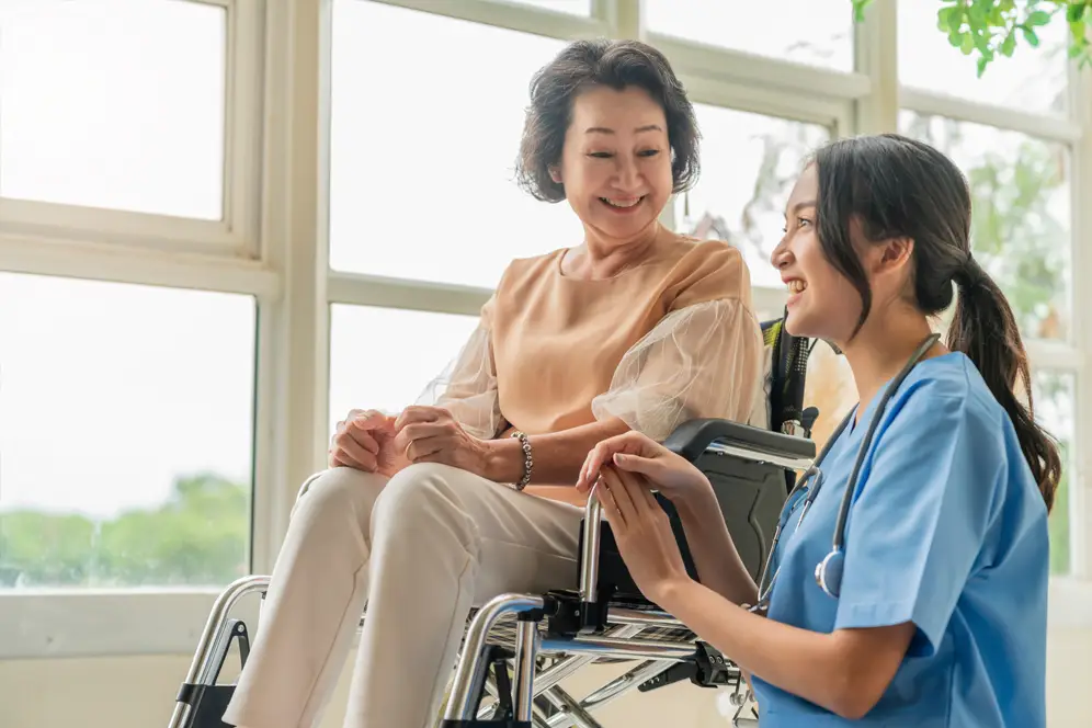 Caretaker talking to elder on a wheelchair